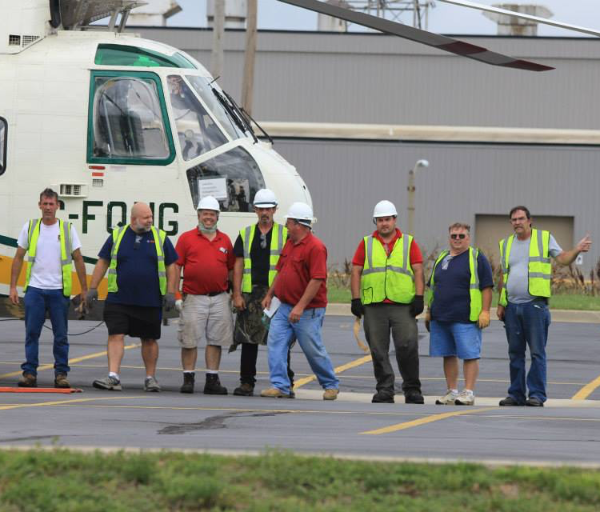 employees in front of helicopter